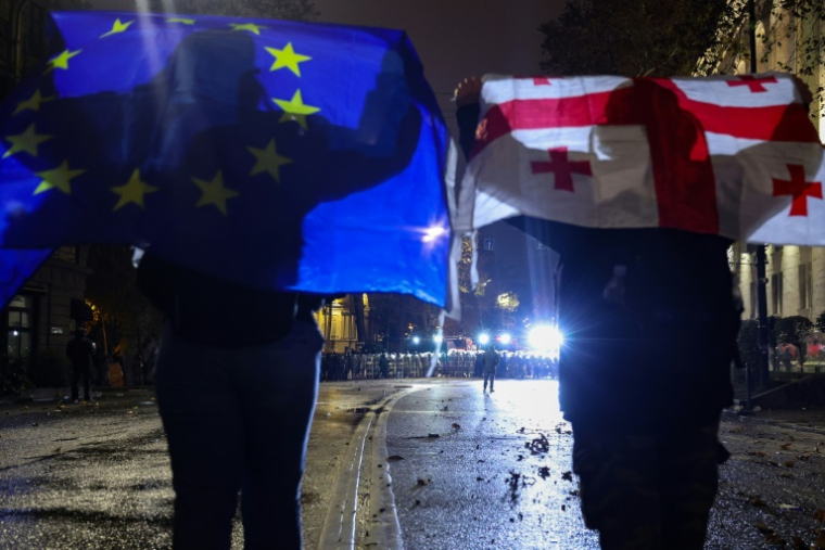 Des manifestants brandissent les drapeaux de l'UE et de la Géorgie pendant une manifestation à Tbilissi, le 3 décembre 2024 ( AFP / Giorgi ARJEVANIDZE )