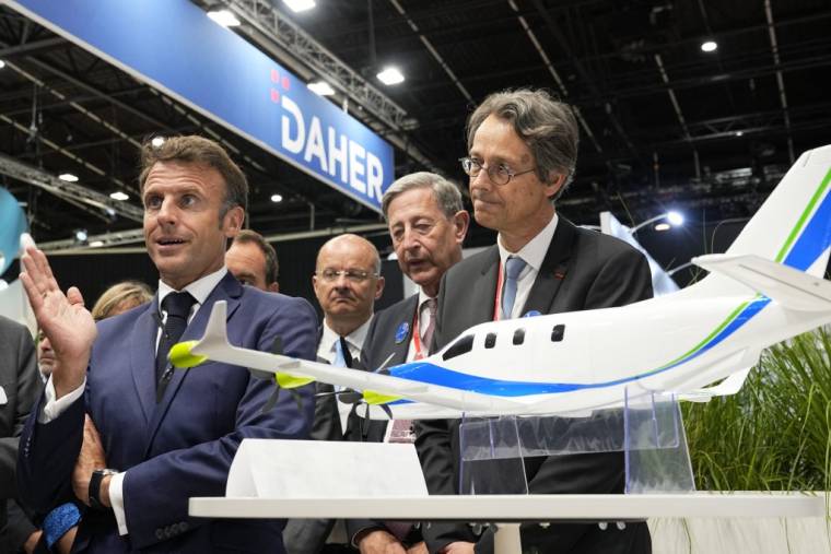 Emmanuel Macron et le PDG de Safran, Olivier Andries (à droite), devant une maquette d'avion du projet Daher Ecopulse, au Salon international du Bourget le 19 juin 2023.  ( POOL / MICHEL EULER )