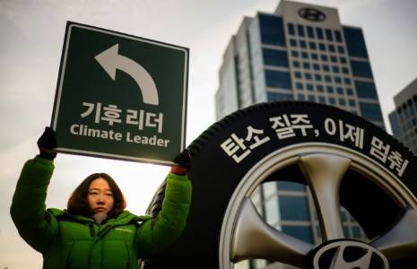 Une militante de Greenpeace lors d'une action de protestation contre les SUV devant le siège du géant automobile sud-coréen Hyundai à Séoul le 29 novembre 2023 ( AFP / ANTHONY WALLACE )