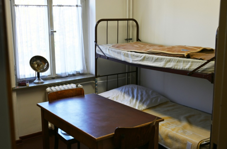 lit superposé, une table et des chaises sont visibles dans une pièce originale conservée au musée du centre de réfugiés de Marienfelde, dédié à l'histoire des vols dans l'Allemagne divisée, à Berlin-Marienfelde, le 16 octobre 2024 ( AFP / Ralf Hirschberger )