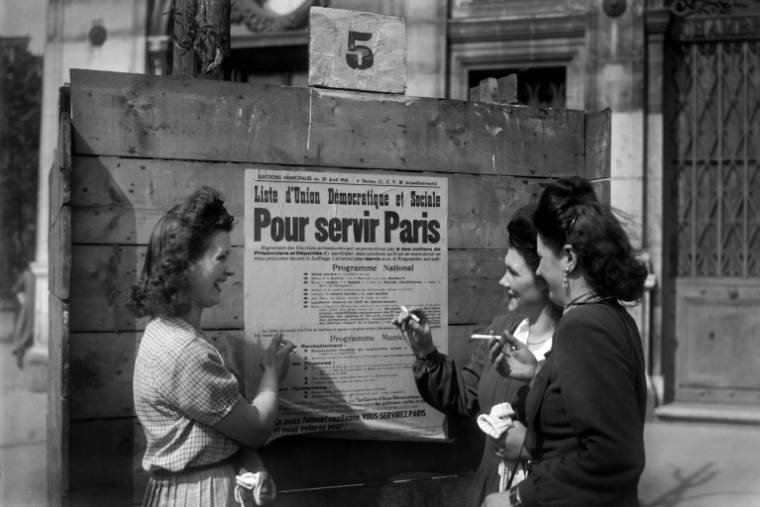 Des femmes devant une affiche électorale à Paris, le 29 avril 1945  ( INTERCONTINENTALE / - )