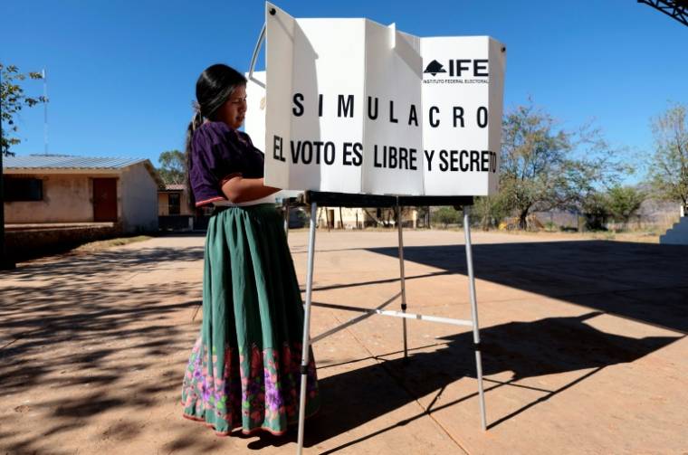 Une femme de la communauté autochtone Wixarika participe à un simulacre de vote lors d'une répétition des élections du 2 2024 organisée par l'Institut national électoral (INE) à Tuxpan de Bolaños, Jalisco, dans l'ouest du Mexique, le 18 mai 2024 ( AE / ULISES RUIZ )