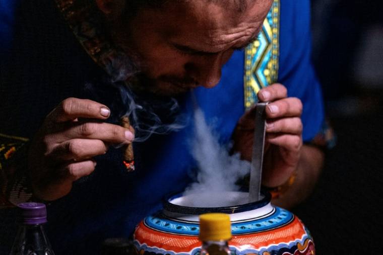 Un assistant du chaman colombien Claudino Perez participe à une cérémonie de yage ou ayahuasca à La Mesa, dans le département de Cundinamarca, en Colombie, le 9 mars 2024 ( AFP / Luis ACOSTA )