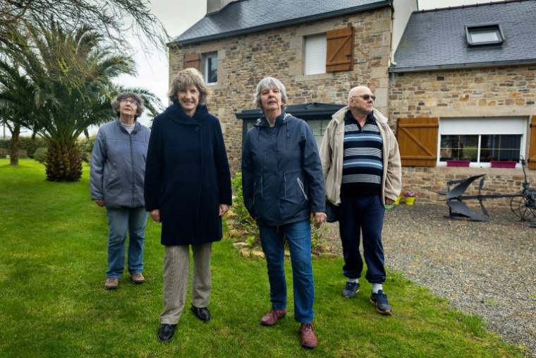 (g-d) Michèle, Marie-Annick, Jeanine et Jean-Pierre Salaun devant la maison où  leur mère, Catherine Tournelle, a été violée par un G.I. en août 1944, le 14 mars 2024 au Drennec, dans le Finistère ( AFP / Fred TANNEAU )