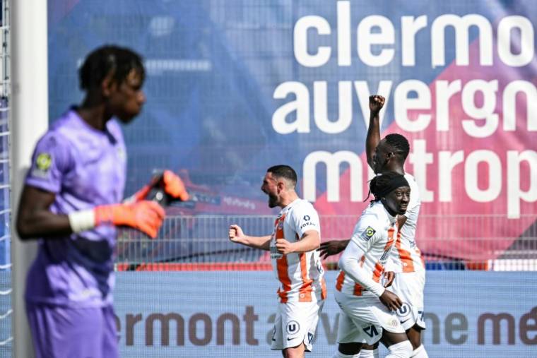 Tanguy Coulibaly (2eD) félicité par ses coéquipiers après avoir égalisé pour Montpellier à Clermont, le 14 avril 2024 ( AFP / JEFF PACHOUD )