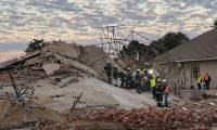 Des équipes de secours sur le site de l'effondrement d'un immeuble en construction à George, le 7  mai 2024 en Afrique du Sud ( AFP / Willie van Tonder )