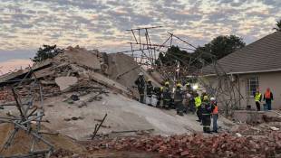 Des équipes de secours sur le site de l'effondrement d'un immeuble en construction à George, le 7  mai 2024 en Afrique du Sud ( AFP / Willie van Tonder )