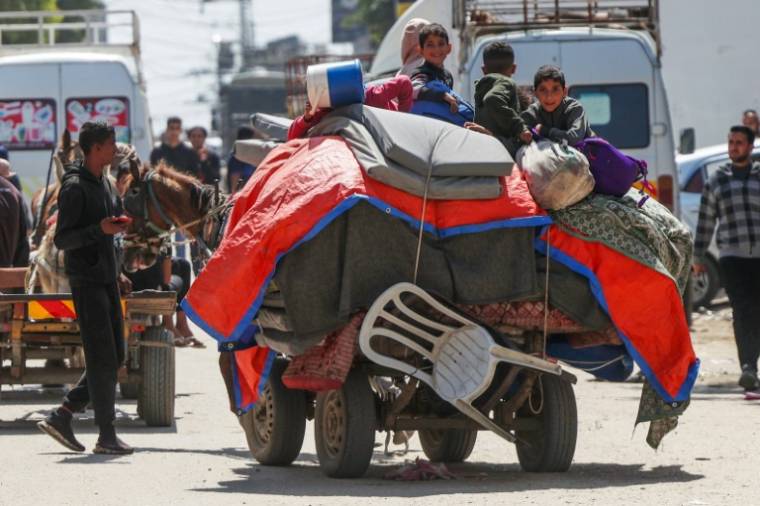 Des enfants palestiniens assis sur leurs affaires transportées sur une charrette tirée par un cheval pour fuir les bombardements israéliens à Nousseirat, dans le centre de la bande de Gaza, le 12 avril 2024 ( AFP / - )
