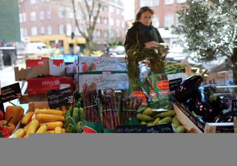 Une cliente achète des légumes à l'épicerie fine Andreas à Londres