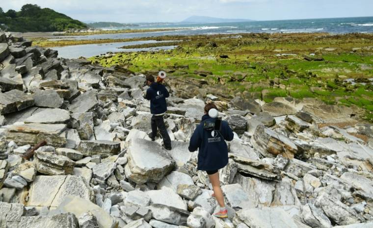 Des employés de l'Observatoire de la Côte de Nouvelle Aquitaine, effectuent des relevés cartographiques de l'érosion du littoral basque à Guéthary, dans les Pyrénées-Atlantiques, le 10 juin 2024 ( AFP / GAIZKA IROZ )