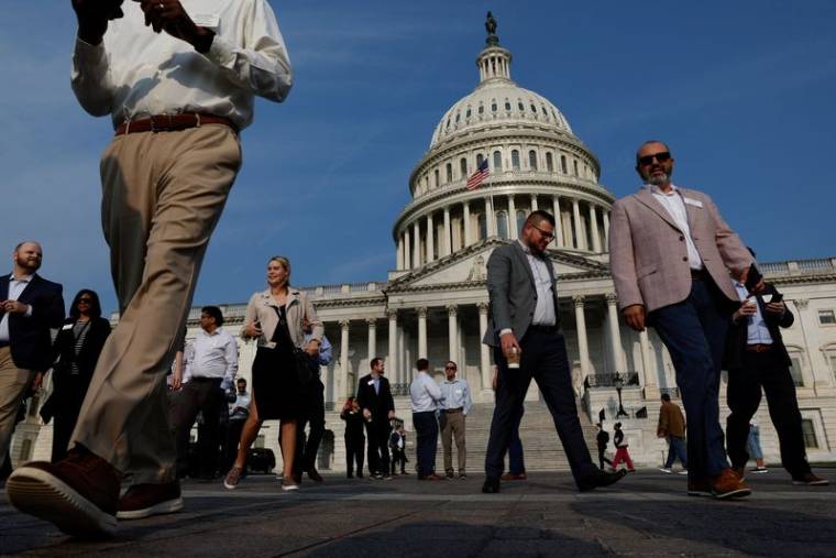 Des visiteurs marchent sur l'esplanade du Capitole à Washington