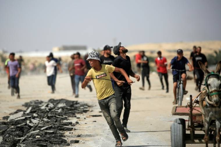 Des Palestiniens courent se mettre à l'abri pendant une attaque israélienne au drone à Rafah, dans le sud de la bande de Gaza, le 29 juin 2024 ( AFP / Eyad BABA )