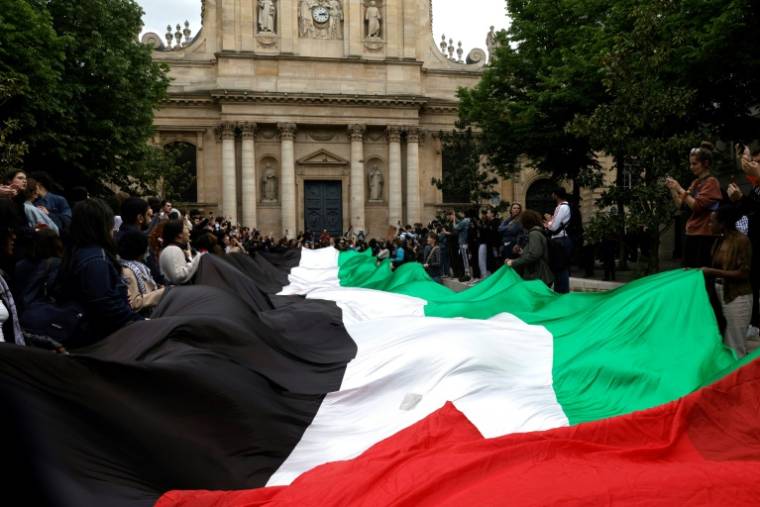 Un drapeau palestinien déployé par des manifestants devant la Sorbonne le 29 avril 2024 à Paris ( AFP / Geoffroy VAN DER HASSELT )