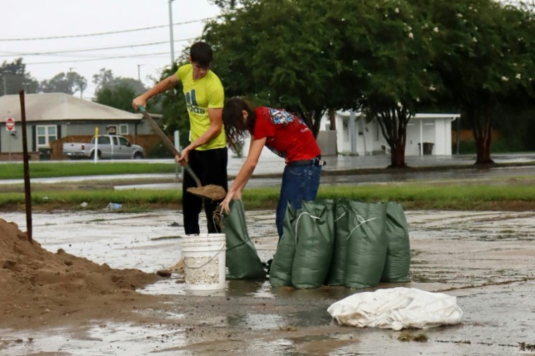 Des habitants remplissent des sacs de terre  pour empêcher l'eau d'entrer dans les  habitations à Houma, au passage de l'ouragan Francine, le 11 septembre 2024 en Louisiane ( AFP / Will McGrew )