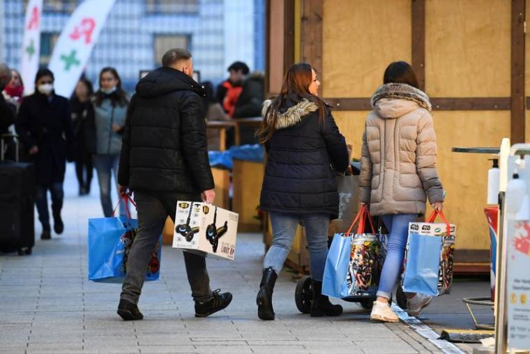 Photo des gens portant des sacs près d'un centre commercial