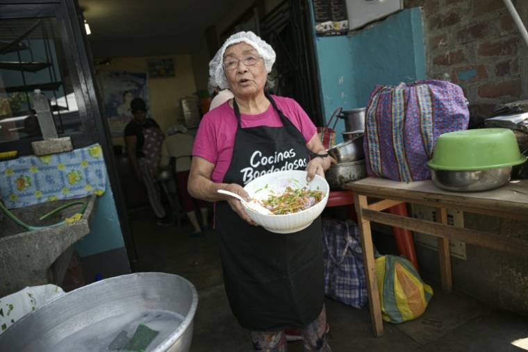 Isabel Santos prépare un plat avec des épluchures de légumes pour tirer le meilleur parti de la nourriture dans une soupe populaire à Lima, le 5 avril 2024 ( AFP / ERNESTO BENAVIDES )