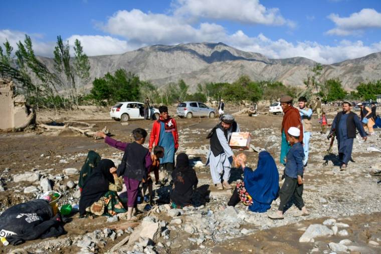 Des Afghans assis près de maisons détruites à cause de crues, dans le quartier de Burka, dans la province de Baglhan, au nord du pays, le 12 mai 2024 ( AFP / Atif ARYAN )