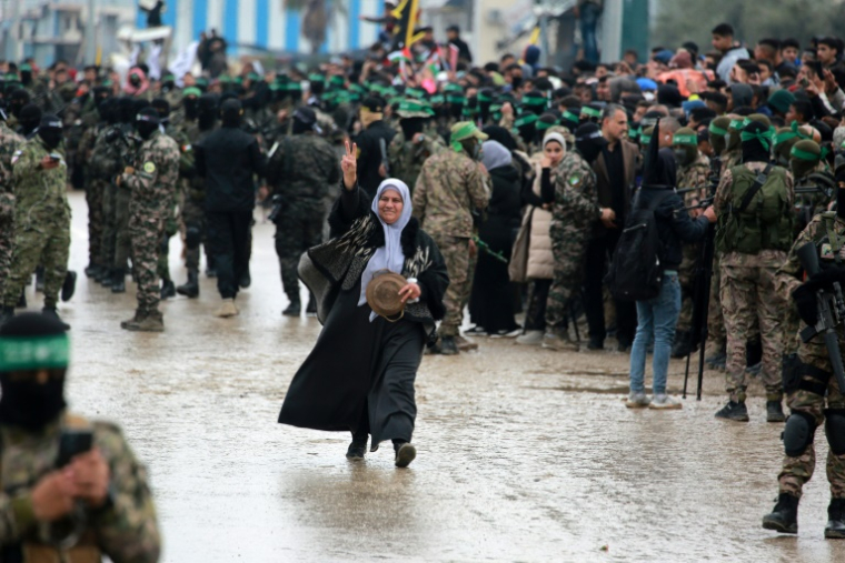 Une Palestinienne parmi des combattants du Hamas, avant la libération d'otages israéliens, à Nousseirat, dans le centre de la bande de Gaza, le 22 février 2025 ( AFP / Bashar TALEB )