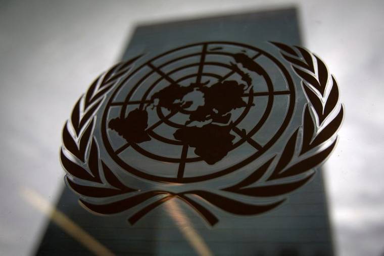 Le siège des Nations unies vu à travers une fenêtre avec le logo des Nations unies au premier plan