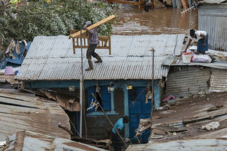 Des habitants du bidonville de Mathare essaient de sauver des biens de leurs maisons inondées, le 24 avril 2024 à Nairobi, au Kenya ( AFP / SIMON MAINA )