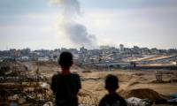 Des garçons regardent la fumée s'élever lors de frappes israéliennes au dessus de l'est de Rafah, dans le sud de la bande de Gaza, le 13 mai 2024 ( AFP / - )