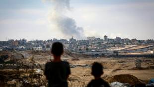 Des garçons regardent la fumée s'élever lors de frappes israéliennes au dessus de l'est de Rafah, dans le sud de la bande de Gaza, le 13 mai 2024 ( AFP / - )