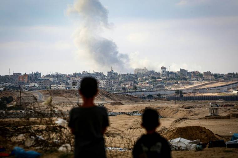 Des enfant regardent la fumée au-dessus de Rafah lors de frappes israéliennes, dans le sud de la bande de Gaza, le 13 mai 2024 ( AFP / - )