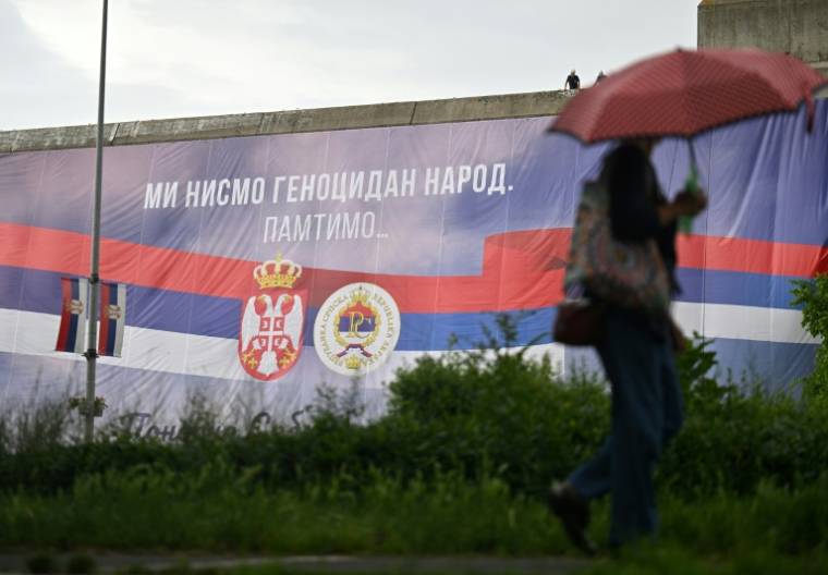 Le message "Nous ne sommes pas une nation génocidaire" sur un drapeau serbe géant déployé sur un bâtiment à Belgrade, le 22 mai 2024 ( AFP / OLIVER BUNIC )