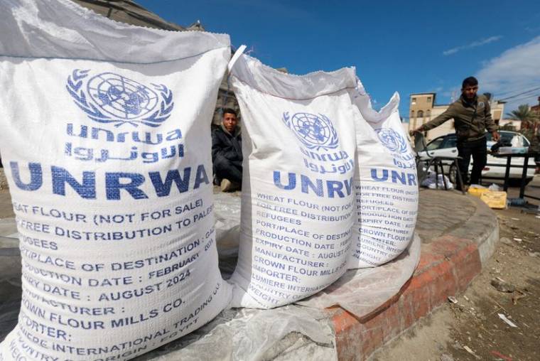 Des Palestiniens déplacés attendent de recevoir de l'aide de l'Office de secours et de travaux des Nations Unies (UNRWA), à Rafah