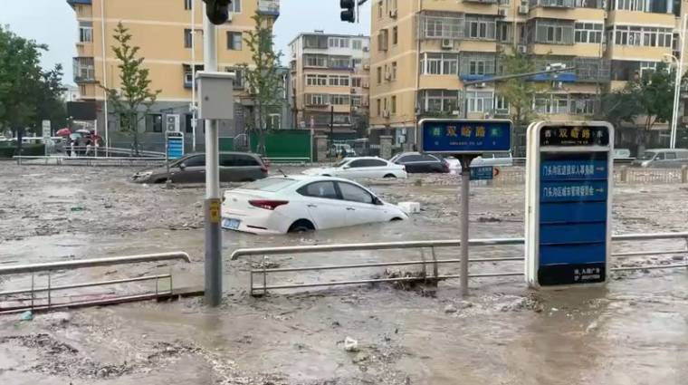 L'eau jaillit dans une rue inondée à la suite du typhon Doksuri à Pékin.