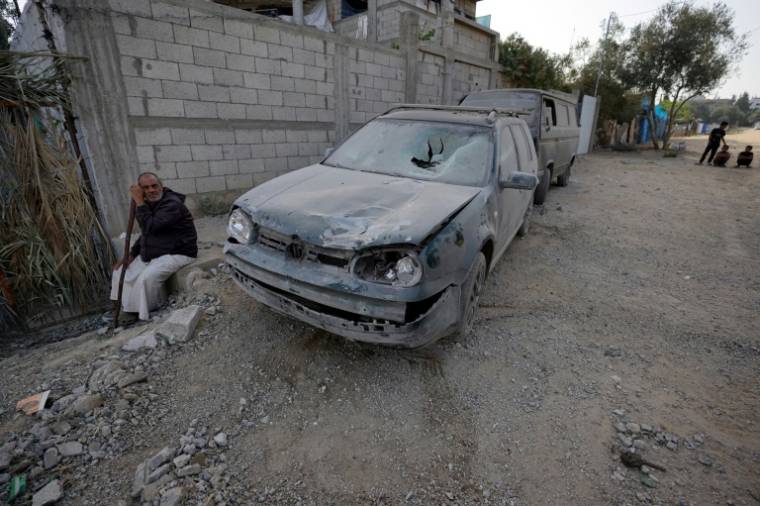 Un homme assis à côté d'une voiture détruite par les bombardements israéliens, le 22 mai 2024, à Gaza, dans les Territoires palestiniens ( AFP / Bashar TALEB )