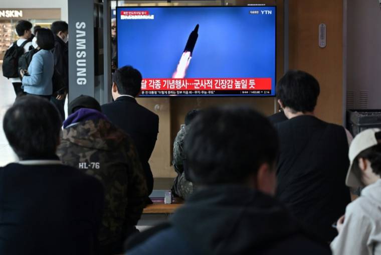 Des passants regardent des images télévisées d'un lancement de missile nord-coréen, dans une gare de Séoul le 2 avril 2024 ( AFP / Jung Yeon-je )