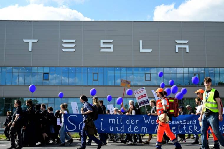 Des manifestants écologistes défilent devant l'usine de Tesla à Grünheide (près de Berlin, en Allemagne) pour protester contre un projet d'agrandissement, le 11  mai 2024 ( AFP / JOHN MACDOUGALL )