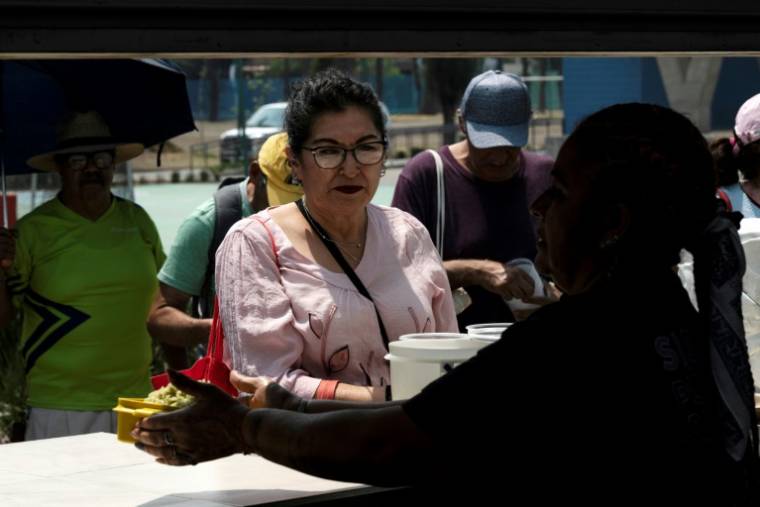 Une femme reçoit de la nourriture pour 11 pesos dans le centre social "Utopia Meyehualco" à Izatapalapa à Mexico, le 15 mai 2024 ( AFP / Yuri CORTEZ )