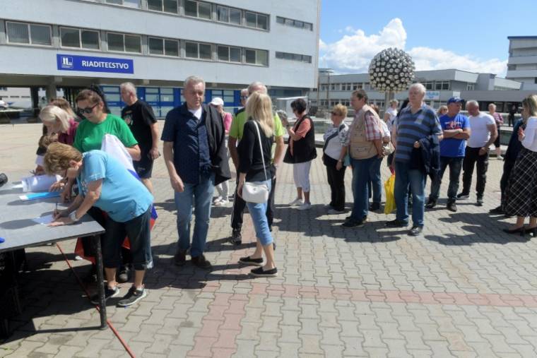 Des sympathisants signent un registre devant l'hôpital universitaire F D Roosevelt où le Premier ministre slovaque Robert Fico est soigné, quatre jours après un attentat dont il a été la cible, le 19 mai 2024 à Banska Bystrica, dans le centre de la Slovaquie ( AFP / Ferenc ISZA )