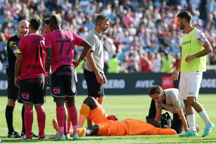 Le gardien de Clermont Mory Diaw (C) est pris en charge après l'explosion d'un pétard à côté de lui, lors du match de Ligue 1 à Montpellier le 8 octobre 2023 ( AFP / Pascal GUYOT )