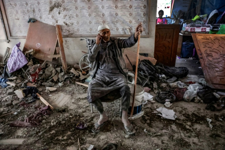 Un homme est assis au milieu des décombres d'une école touchée par des frappes israéliennes meurtrières dans la ville de Gaza, le 10 août 2024 ( AFP / Omar AL-QATTAA )