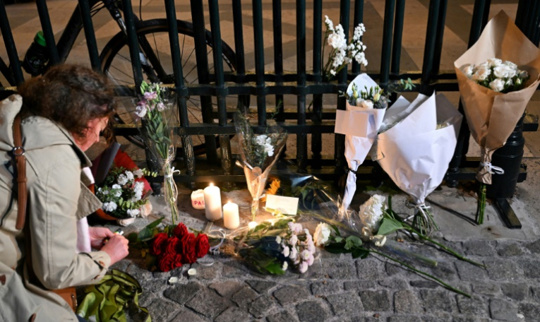 Des fleurs et des bougies déposées en hommage à un cycliste mort écrasé la veille par un véhicule après un différend avec son conducteur, le 16 octobre 2024 à Paris ( AFP / Bertrand GUAY )