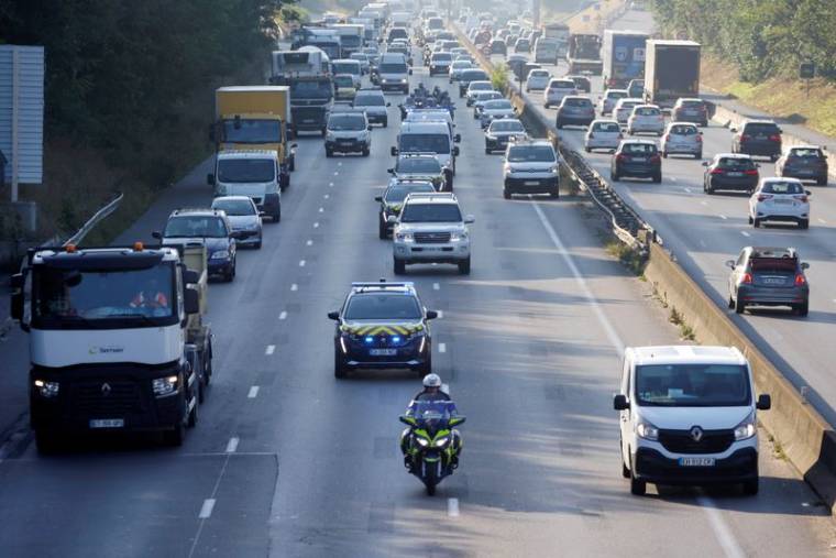 Un convoi de police et d'autres véhicules sur une autoroute près de Paris, France