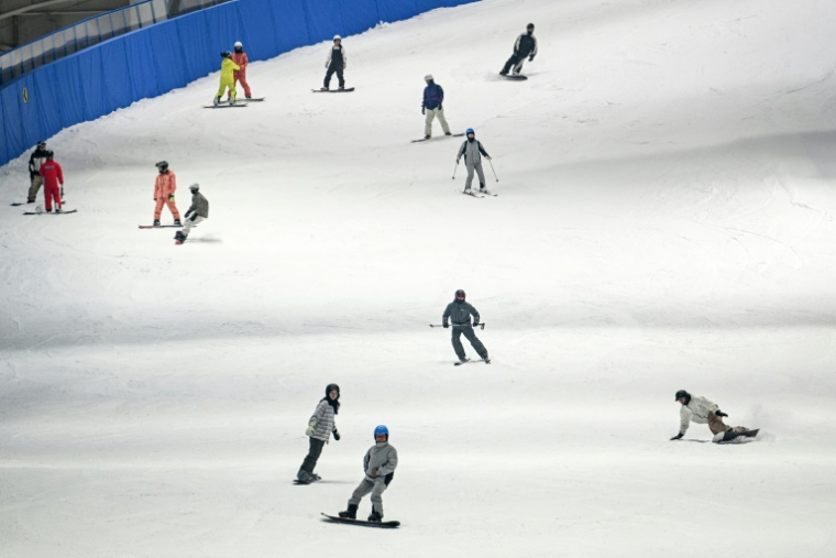 Des skieurs et snowboardeurs à L*SNOW Indoor Skiing Theme Resort, la plus grande piste de ski intérieure au monde, le 6 septembre 2024 à Shanghai ( AFP / Hector RETAMAL )