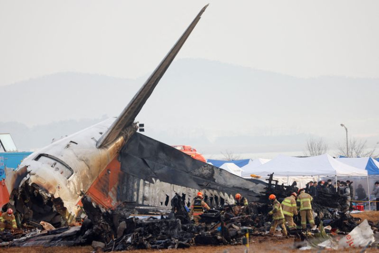 Des personnes travaillent sur le site où un avion est sorti de piste et s'est écrasé à l'aéroport international de Muan, à Muan, en Corée du Sud