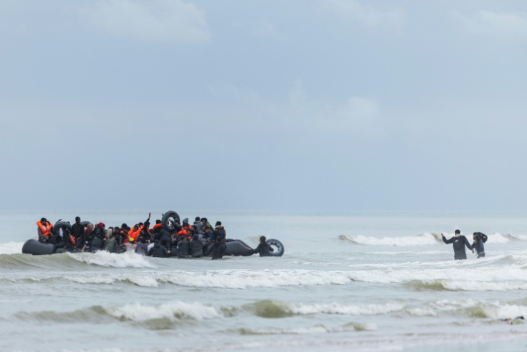 Des migrants se pressent sur le canot pneumatique d'un passeur pour tenter de traverser la Manche, après avoir quitté la plage d'Ecault à Saint-Etienne-au-Mont, dans le nord de la France, le 30 octobre 2024 ( AFP / Sameer Al-DOUMY )