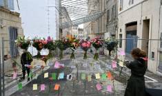 Une femme laisse un message lors d'une cérémonie commémorative marquant le premier anniversaire de l'effondrement d'un immeuble dans la rue Tivoli à Marseille, le 9 avril 2024 ( AFP / Nicolas TUCAT )
