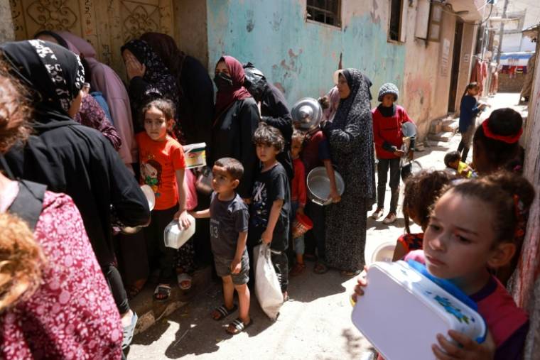 Des enfants font la queue le 19 avril 2024 pour recevoir de la nourriture à Rafah, dans le sud de la bande de Gaza, où une guerre oppose Israël au mouvement islamiste palestinien Hamas ( AFP / MOHAMMED ABED )