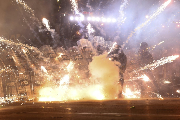 Des manifestants lancent des feux d'artifice en direction des policiers pendant des manifestations à Tbilissi, le 2 décembre 2024 ( AFP / Giorgi ARJEVANIDZE )