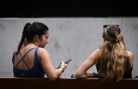 Deux femmes sur un banc à Sydney, le 7 novembre 2024 ( AFP / DAVID GRAY )