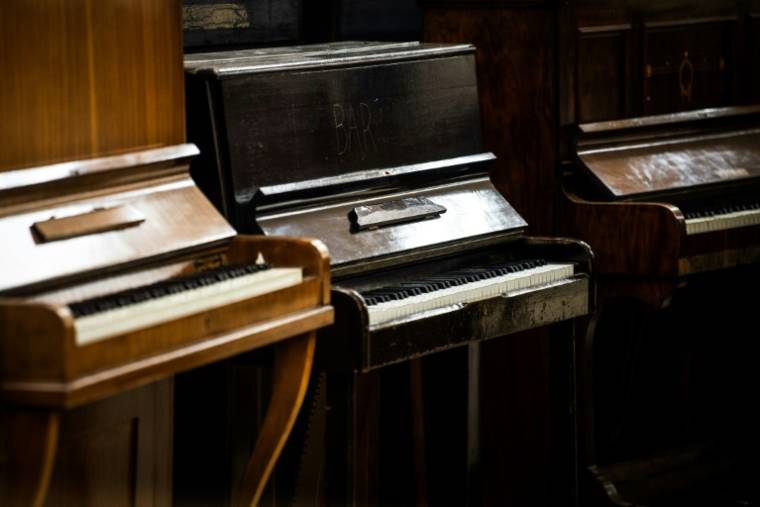 Des vieux pinos dans un atelier de "Pianodrome", le 9 février 2023 à Edimbourg ( AFP / Andy Buchanan )