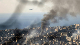 Un avion commercial de la compagnie Middle East Airlines s'approche de la piste de l'aéroport de Beyrouth et survole les panaches de fumée qui s'élèvent du site d'une frappe qui a visé la banlieue sud de la capitale, le 16 novembre 2024 ( AFP / IBRAHIM AMRO )