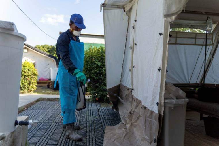 Un employé de santé désinfecte les alentours d'une clinique gérée par Médecins sans frontières où les gens sont traités pour le choléra, à Cité Soleil, une commune densément peuplée de Port-au-Prince, le 7 octobre 2022 en Haïti ( AFP / Richard Pierrin )