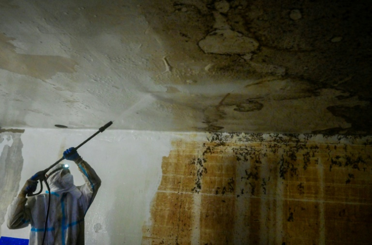 Un habitant nettoie un garage endommagé par les inondations de fin octobre, à Paiporta, près de Valence le 27 novembre 2024 ( AFP / Jose Jordan )